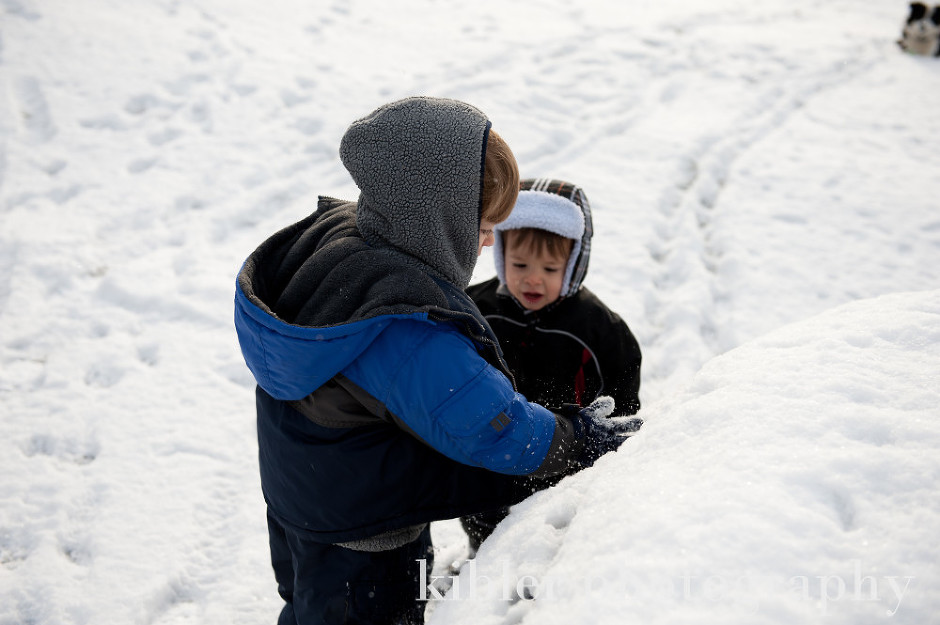 boys cleaning snow off car