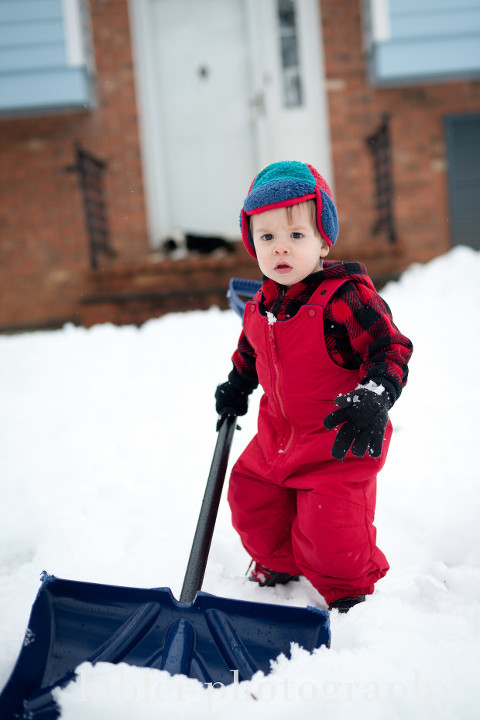 little boy shoveling snow photo