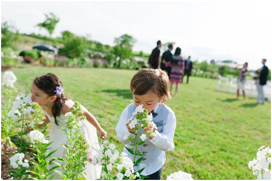 flower girl and ring bearer smelling the beautiful flowers at an Early Mountain Vineyard Wedding-1376.jpg