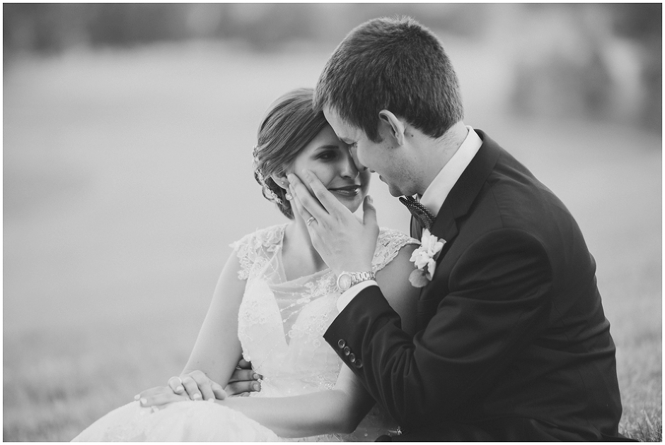 Black and white sweet portrait of bride and groom sitting on the hillside at Trump Winery wedding