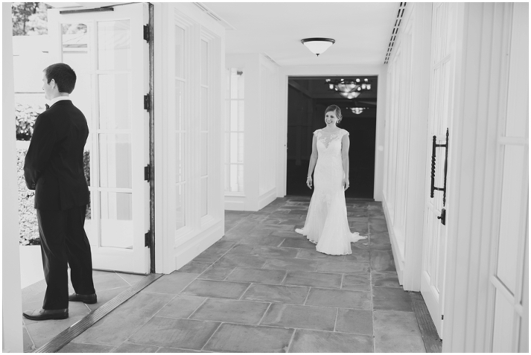 black and white picture of first look with bride walking down hallway at Trump Winery Chapel 