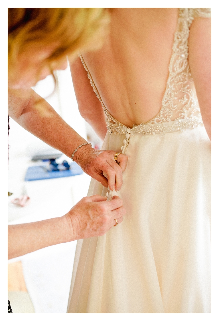 mother of the bride buttoning wedding dress at a charlottesville wedding